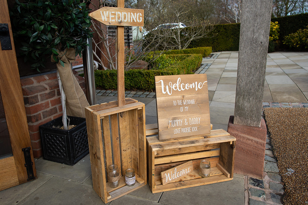 The couple chose wooden crate wedding signs for their barn wedding in Cheshire